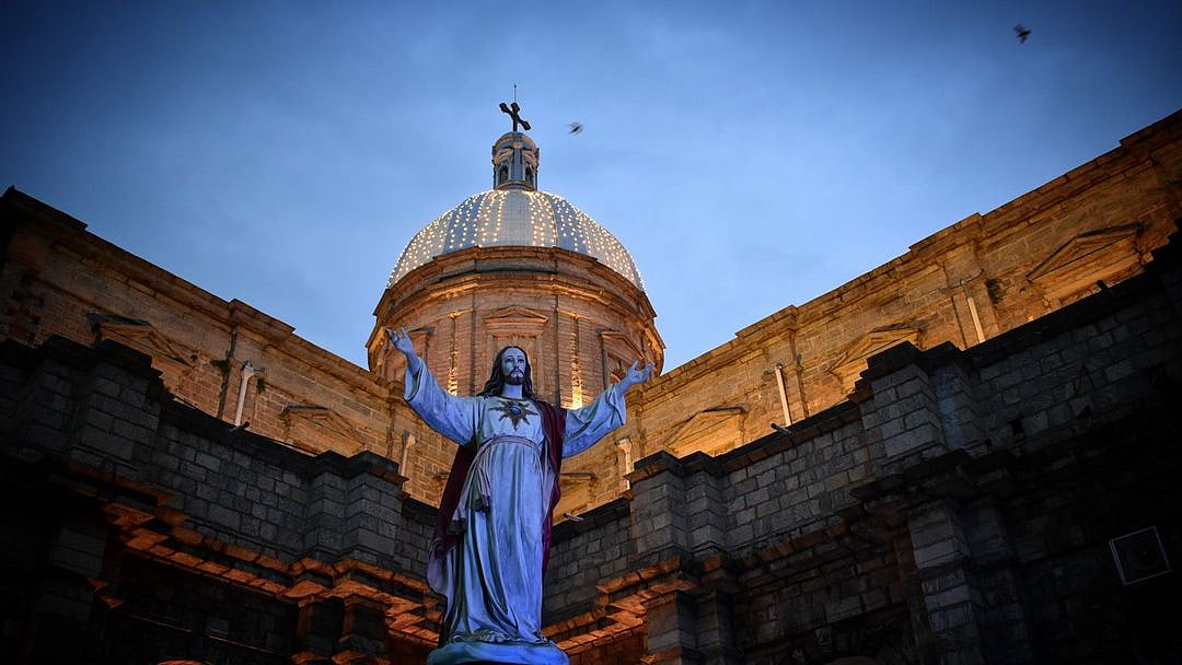 The church is distinguished by three large blue and white cross-topped domes illuminated at night